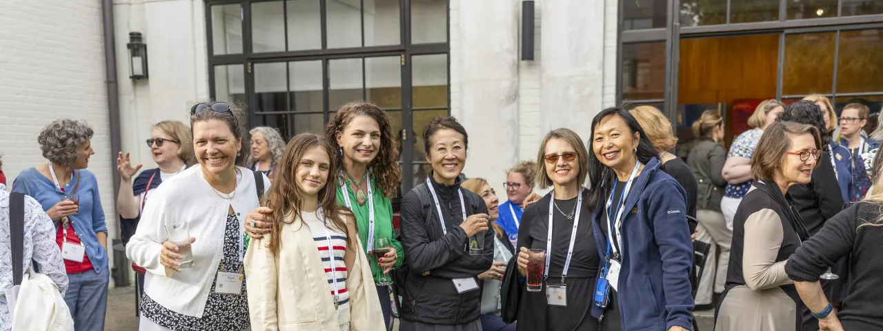 Group of alums wearing name tags looking at the camera and smiling