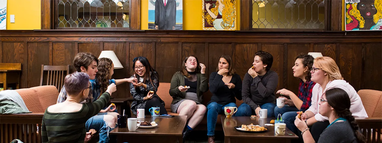 Group of students having tea in a house living room