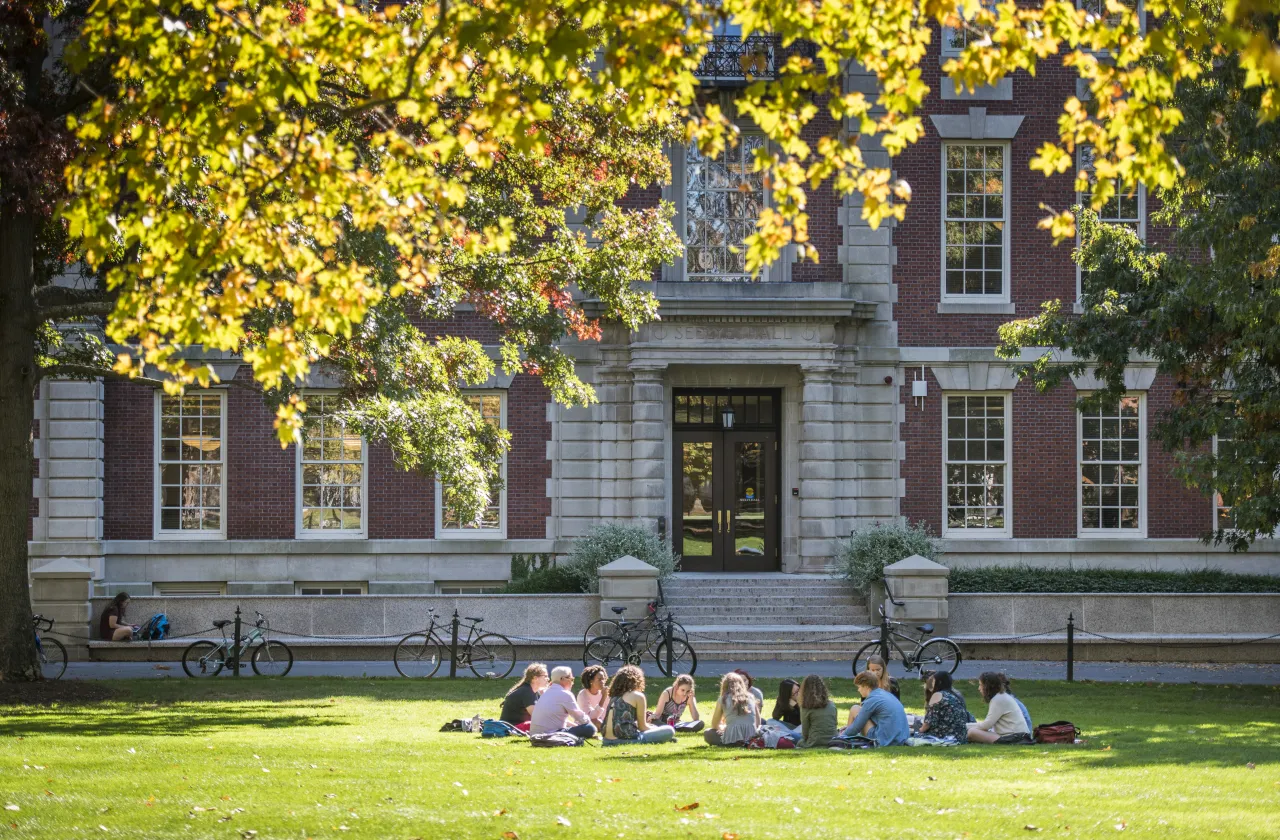 Students sitting on the lawn in front of Seelye Hall.