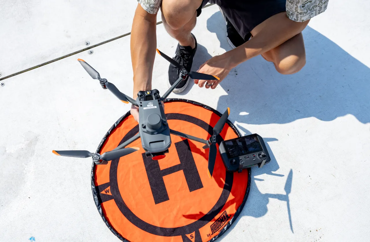 Kala'i Ellis holds Patty the Drone over an orange landing target