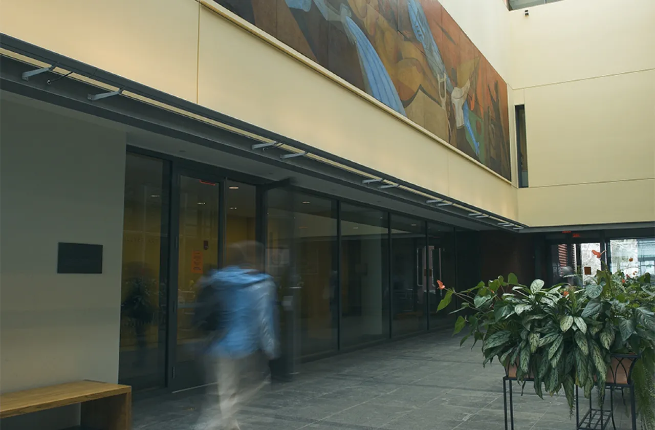 person with backpack walks through the atrium at the museum