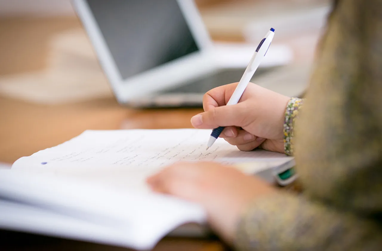 Closeup of a student writing in a notebook