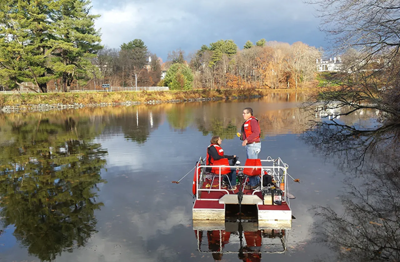 Student and professor conducting research on the pond