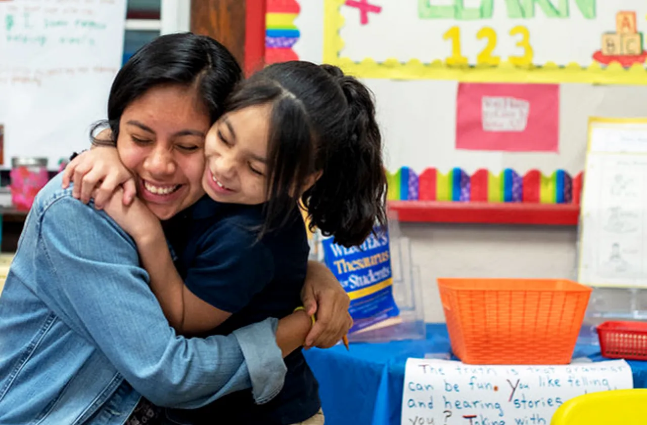 Smith student doing community service and hugging a child in school