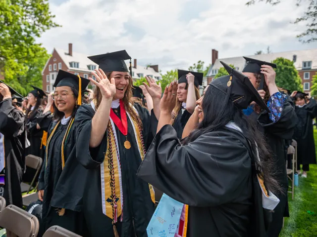 Graduates high-fiving one another.