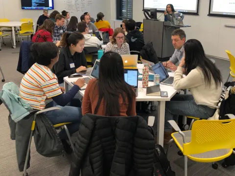 Students and a prof around a round table collaborating