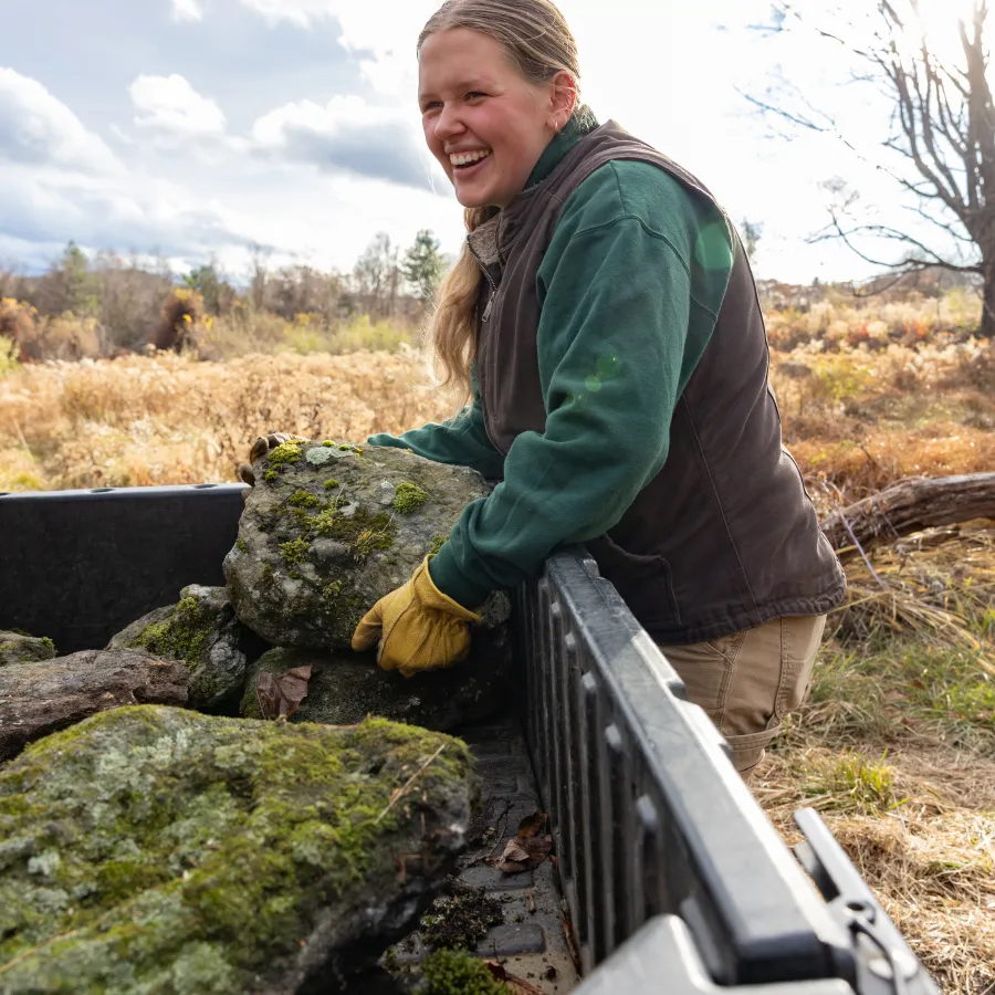 Smith student Alex Blaszczyk ’27 moves rocks at MacLeish to make a home for snakes