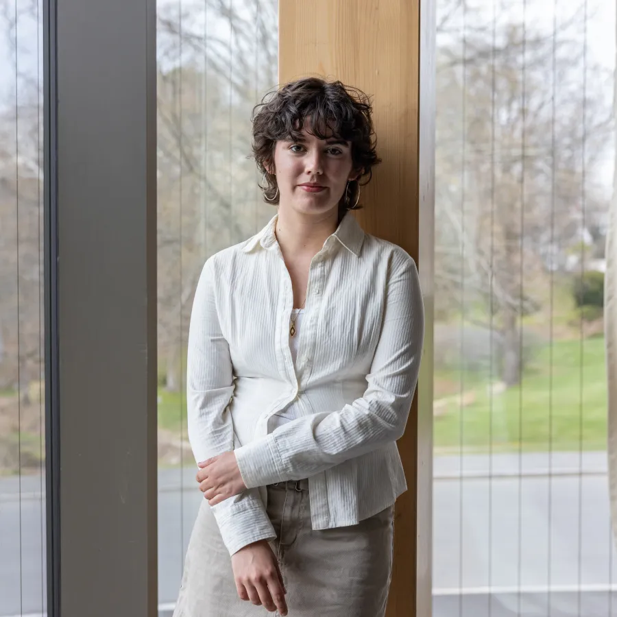 Smith College senior Gabriela Eastwood leans against some paneling in a campus building