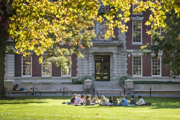 Students sitting on the lawn in front of Seelye Hall.