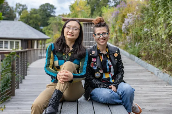 Shiya Cao and Heather Rosenfeld sit on a bench near Paradise Pond