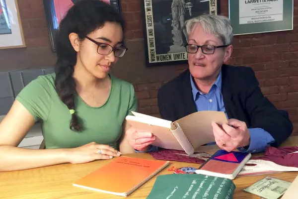 Alicia Bowling '17 (left) and activist Carmen Vazquez, who is featured in Smith's new MOOC, review materials Vazquez donated to Smith's Sophia Smith Collection.