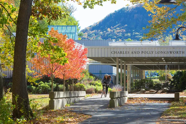 Student riding a bike on the Hampshire College campus