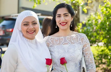 Two students holding roses on Ivy Day.