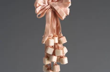 Light pink corsage made of ribbons and sugar cubes.