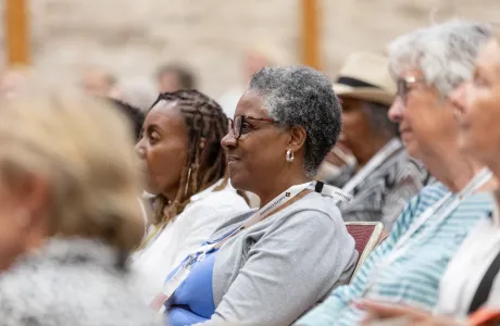 An alum smiles while listening to a panel discussion during Reunion
