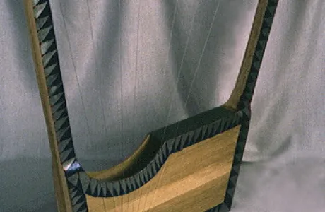 A wooden lyre with a rectangular base and a curved top arm, featuring eight strings