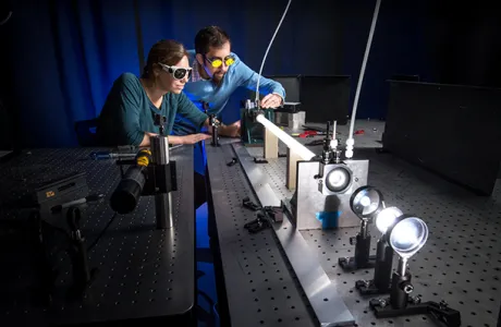 Assistant Professor Andrew Berke with student in laser lab