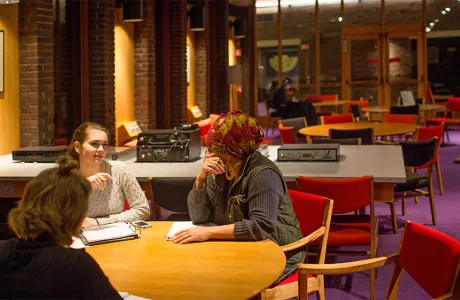 Interior of Josten Library with four students working at a table