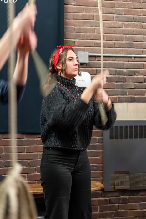 Change ringing in the Mendenhall Bell Tower with a student wearing a red bandana pulling a rope