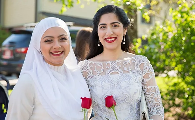 Two students holding roses on Ivy Day.
