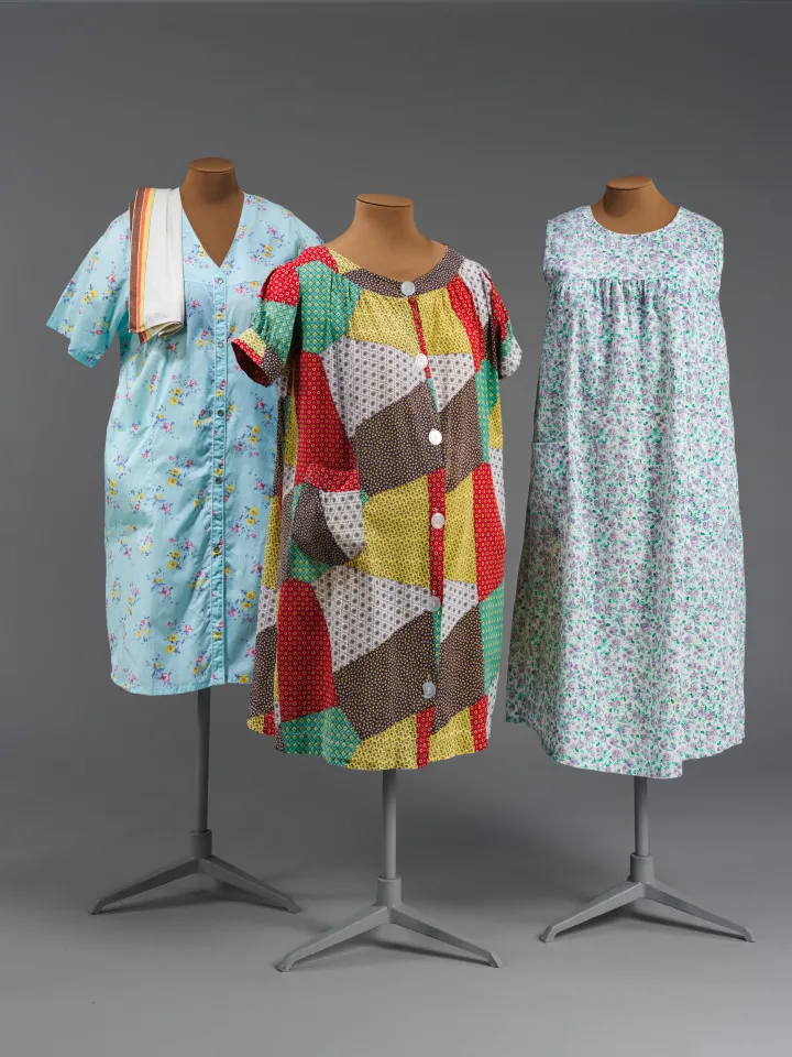 Three knee-length housecoats on mannequins with various patterns and colors.