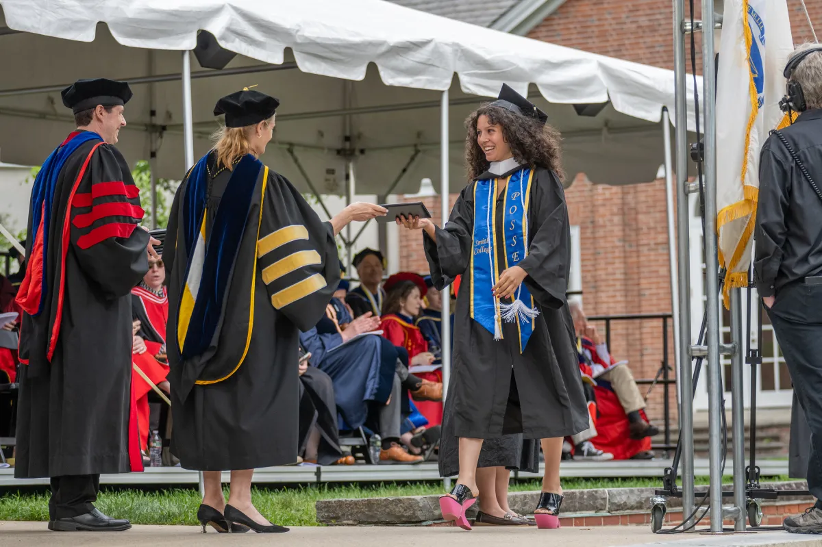 A graduate walks across the stage during Commencement
