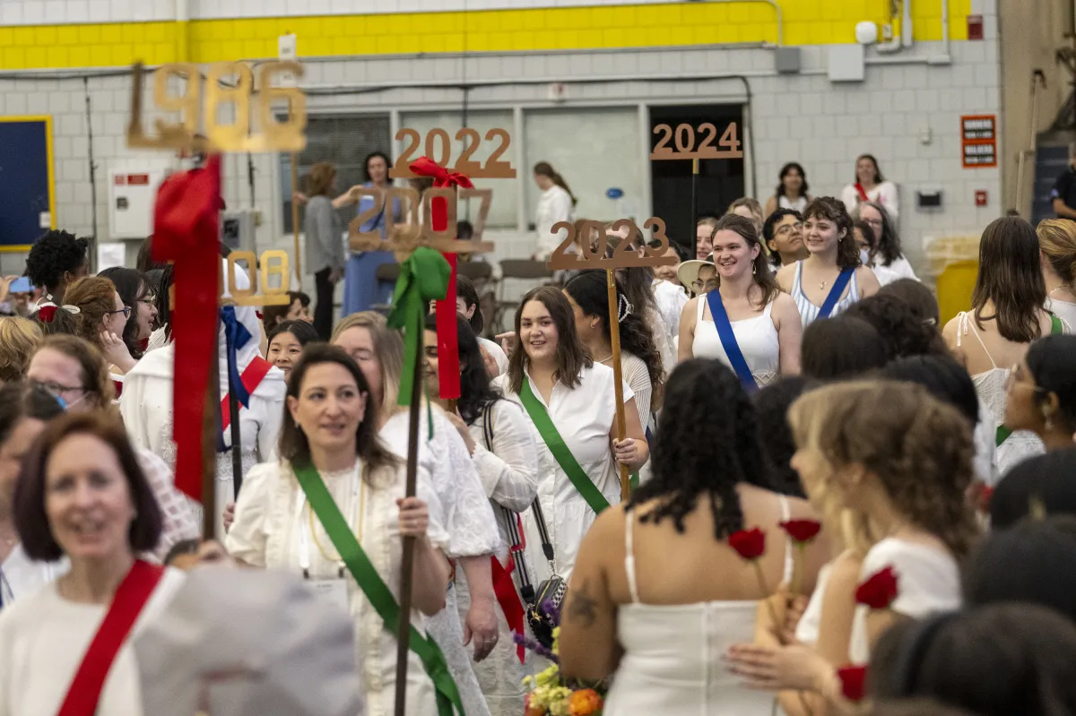 A group of alums from all different class years walk into the Ivy Day ceremony