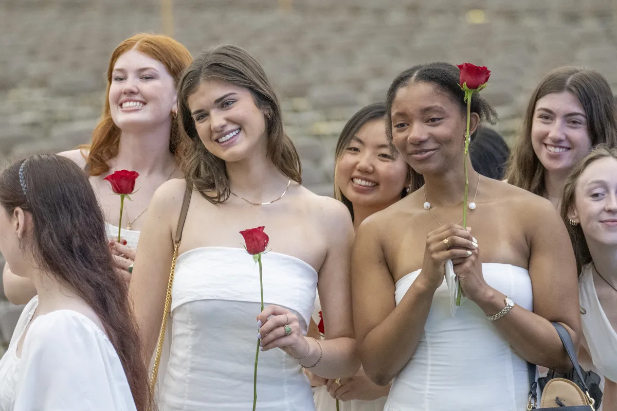 Seniors smile and hold roses on Ivy Day