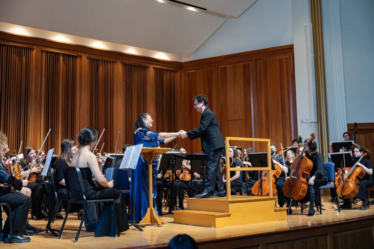 President Sarah onstage with the Smith orchestra during Smith Arts Day 2025.