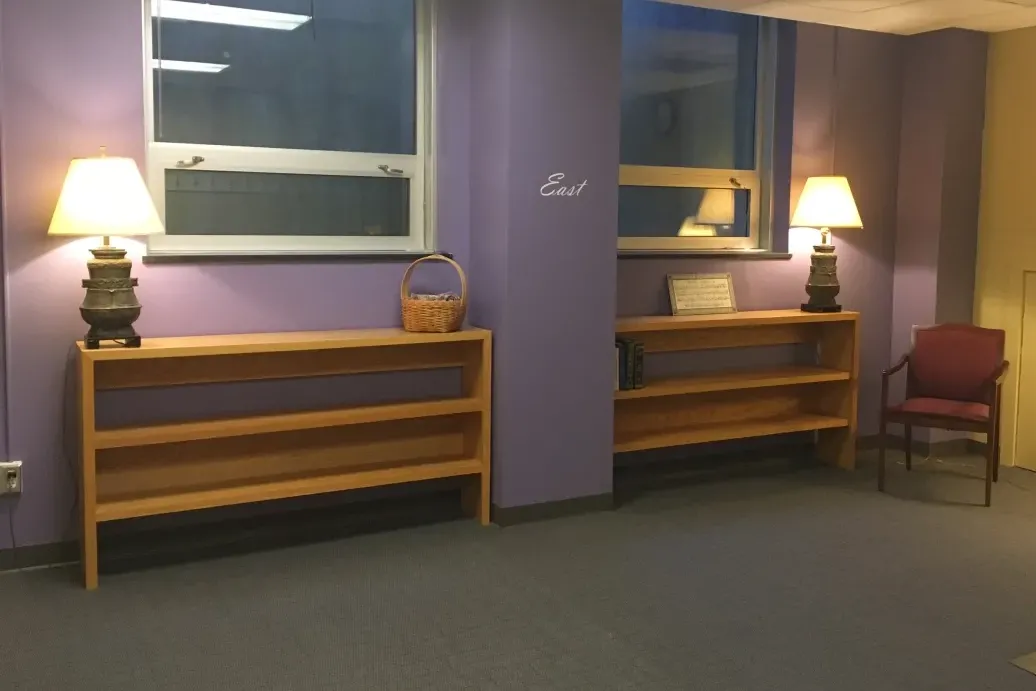 A room with purple walls, soft lighting, and directions noted on the walls.