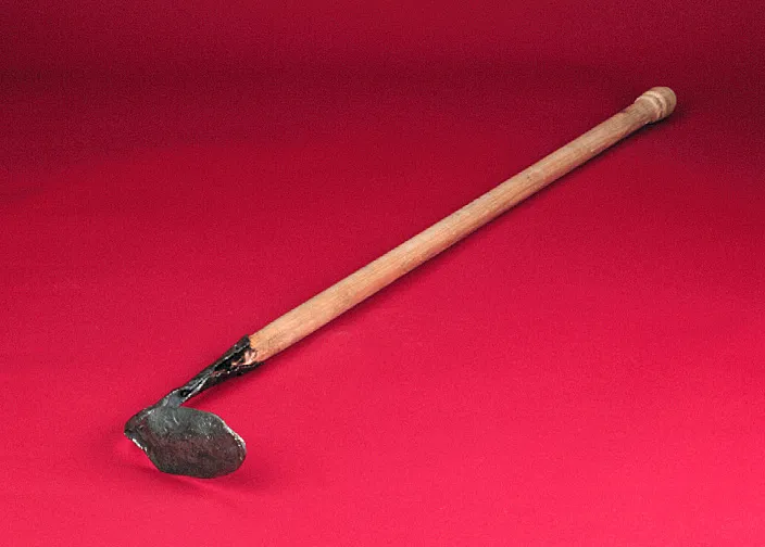 A wooden-handled hoe with a small, worn metal blade