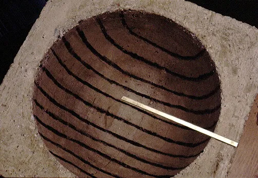 A concrete block with a circular cutout featuring parallel dark lines across its surface