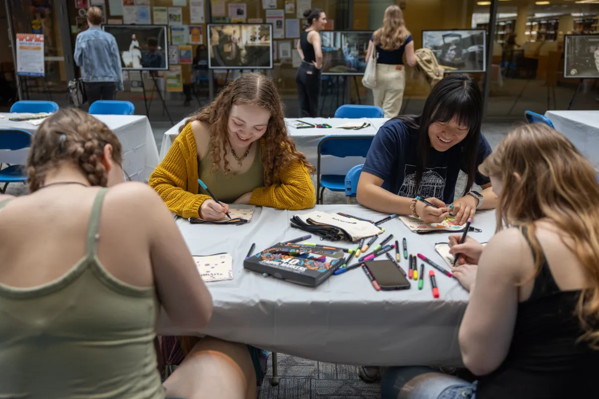 Students sitting and decorating Smith Arts pencil pouches