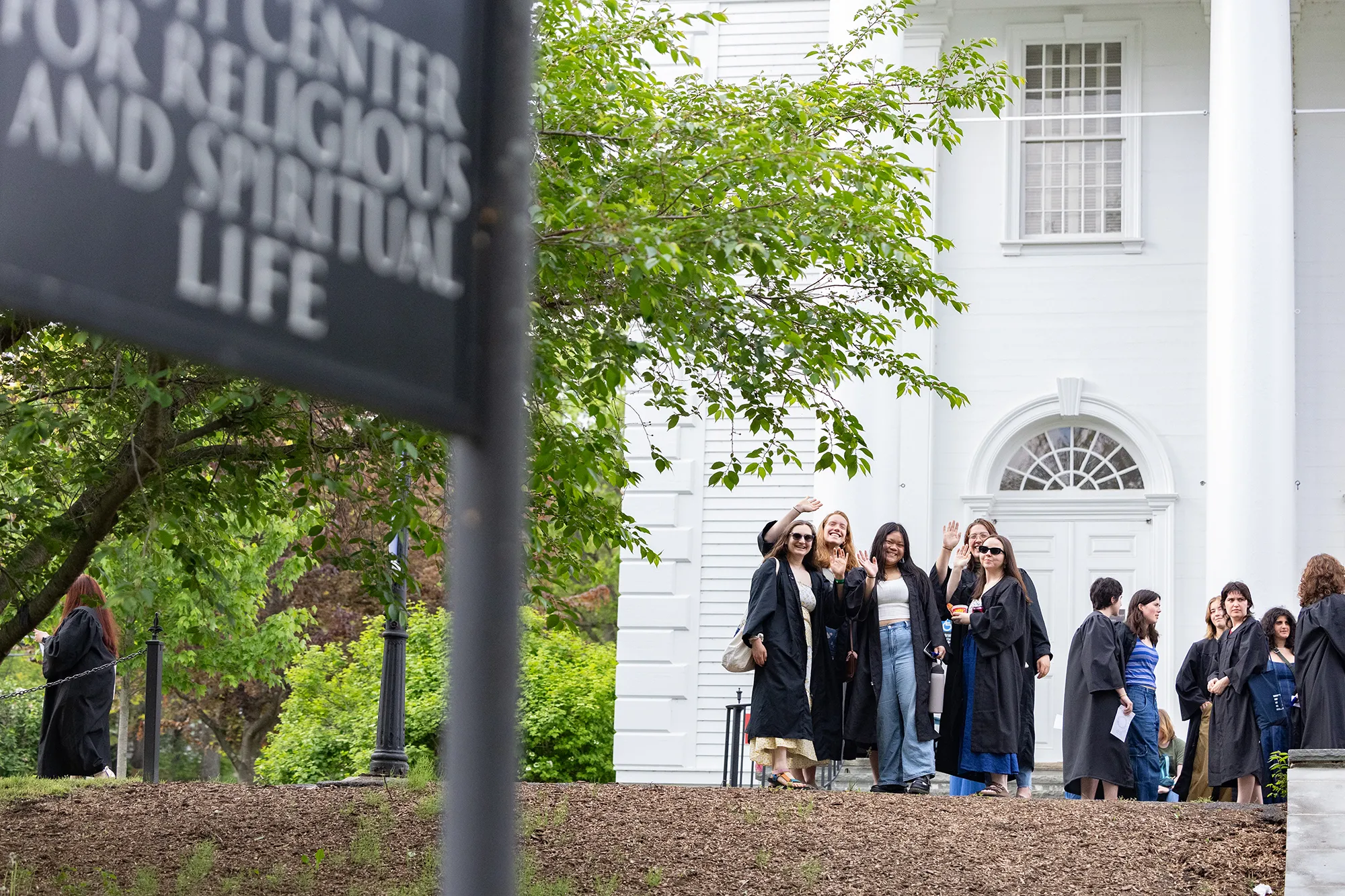 A group of seniors in their gowns pose in front of the Chapel