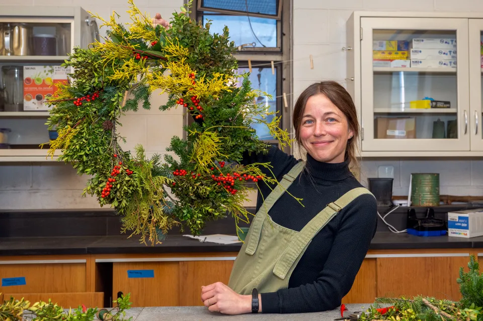 Julie Thomson smiles while holding a completed wreath