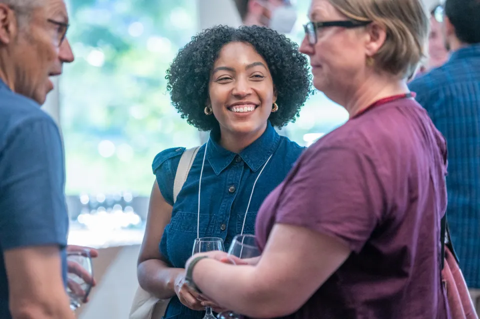 A new faculty member smiling at the new faculty reception in 2023
