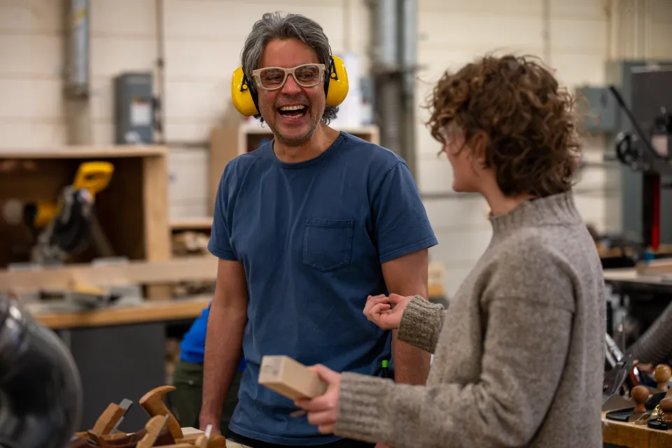 Woodshop supervisor Drew Palmore laughs with Eliza Berle ’27 in the Hillyer Hall Woodshop