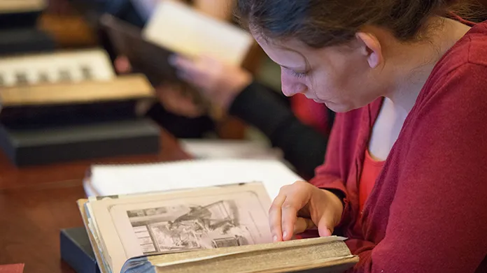 Student paging through book in the Rare Book Room