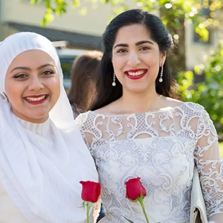 Two students holding roses on Ivy Day.