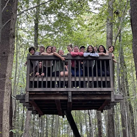 Students smile from atop a wooden platform at MacLeish Field Station