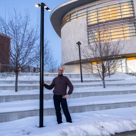Professor James Lowenthal stands next to a night sky-friendly outdoor light behind the Smith library