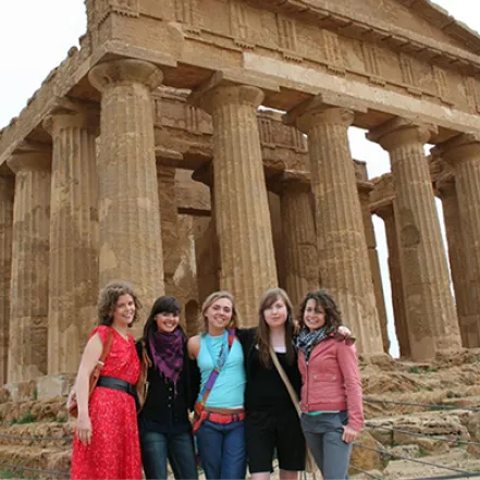Photo of students posing in front of ancient ruins in Italy