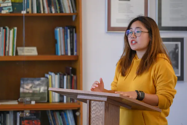 A student reading a poem at a podium